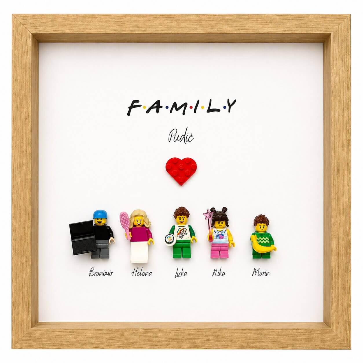 Personalizirani LEGO okvir obitelji Pudić u drvenom okviru s pet figurica, LEGO srcem i natpisom Family.
